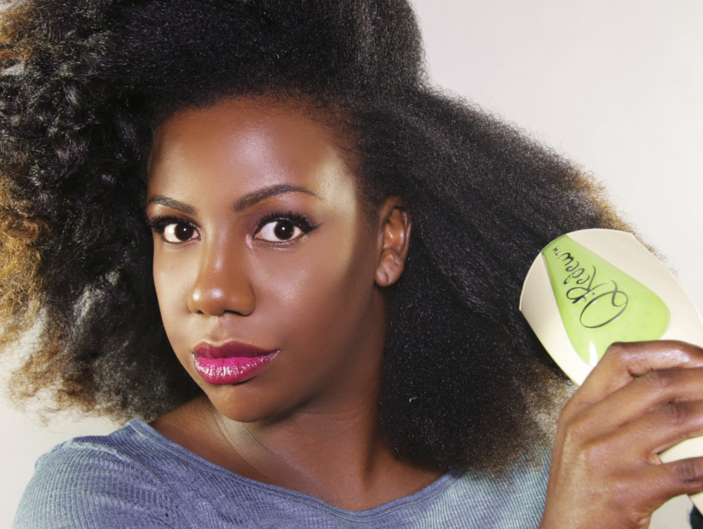 A woman with 4C curly hair using a Q-Redew handheld hair steamer